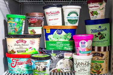 Mint chocolate chip ice creams stacked in a freezer.